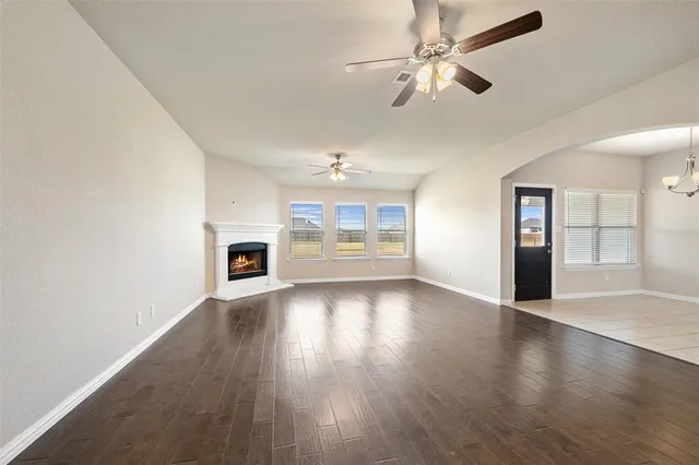 a view of an empty room with window and wooden floor