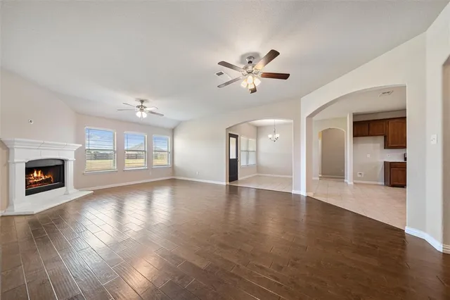 a view of an empty room with a fireplace and wooden floor