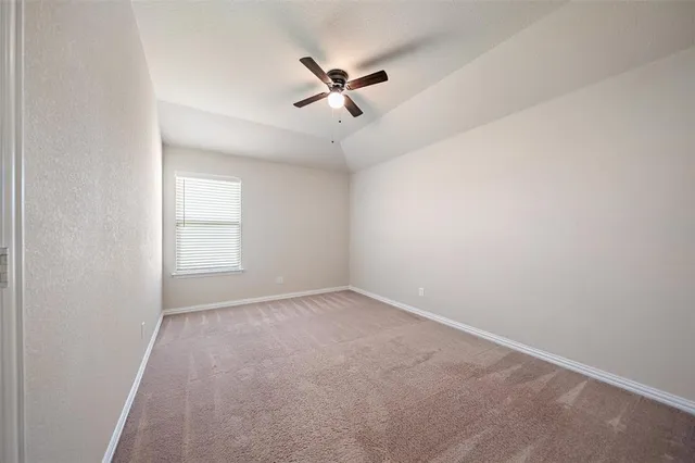 an empty room with a ceiling fan and window