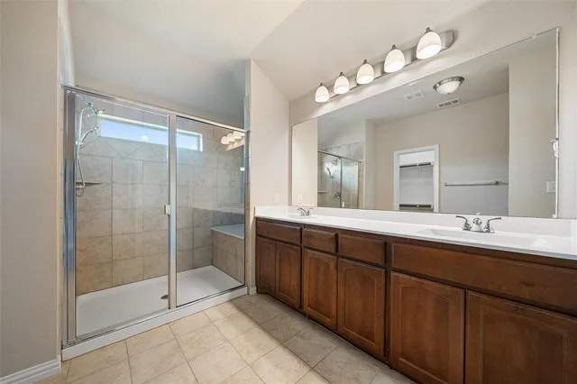 a bathroom with a double vanity sink mirror and shower