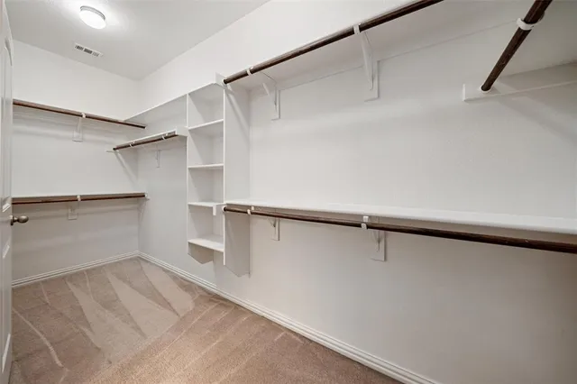 a view of walk in closet with empty racks