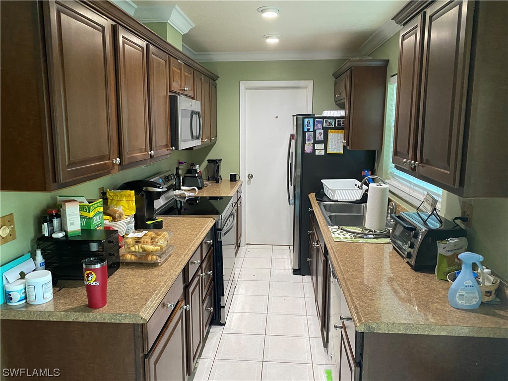 5968 Bay Point Road Bokeelia, FL 33922 - Photo 3 of 11 a kitchen with stainless steel appliances granite countertop a refrigerator a stove and a sink