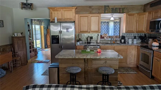 a kitchen with stainless steel appliances granite countertop a sink a stove and a refrigerator