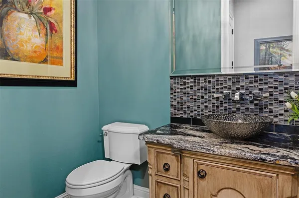 a bathroom with a granite countertop toilet and a sink