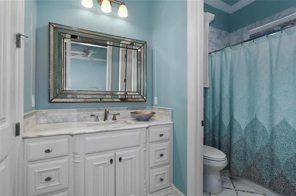 a bathroom with a granite countertop sink toilet and shower