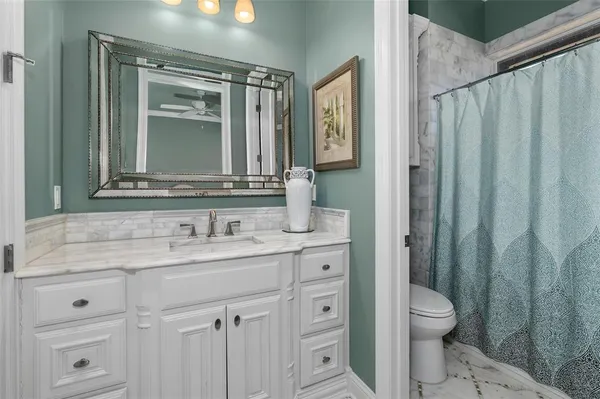 a bathroom with a granite countertop sink toilet and shower