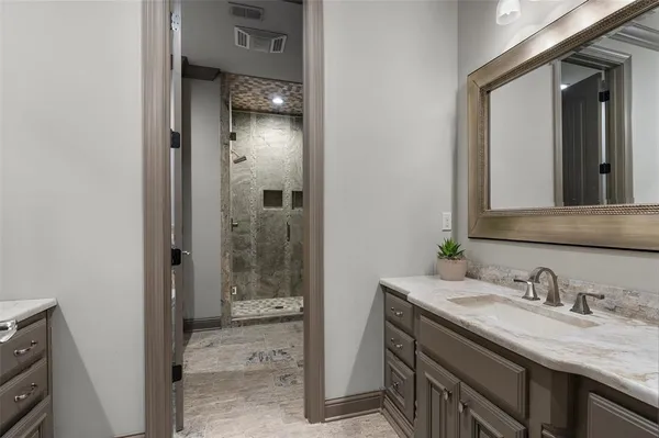 a bathroom with a granite countertop sink and a mirror