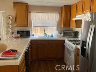 412 Yellowstone Circle Corona, CA 92879 - Photo 5 of 15 a kitchen with granite countertop a sink stainless steel appliances and cabinets