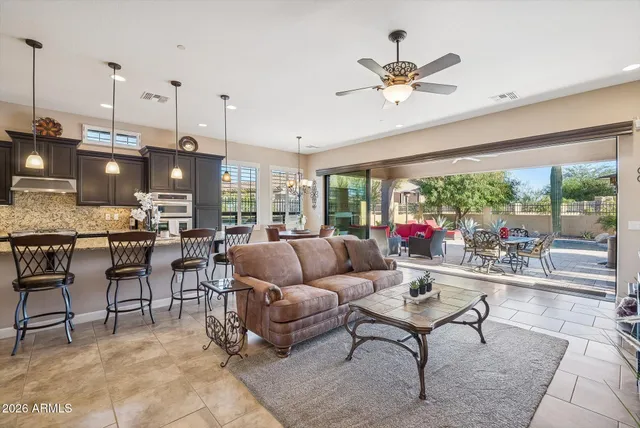 a living room with furniture kitchen view and a chandelier