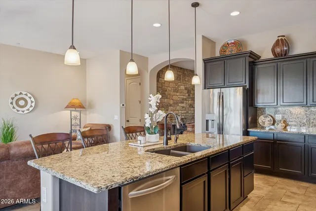 a kitchen with a stove a kitchen island a sink dining table and chairs
