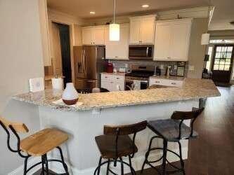 194 Yorkshire Lane Villa Rica, GA 30180 - Photo 4 of 20 a kitchen with stainless steel appliances kitchen island granite countertop a table chairs in it and wooden floors