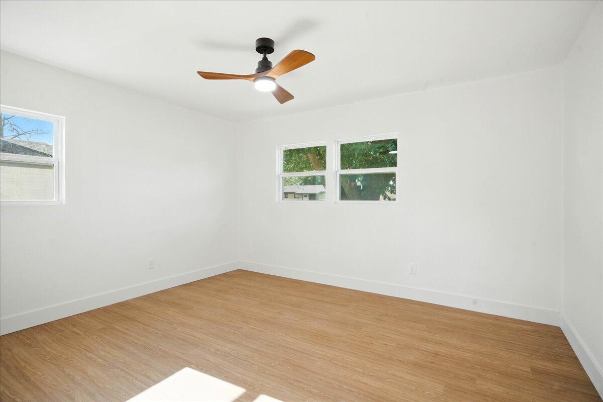 1308 59th Street Lubbock, TX 79412 - Photo 18 of 28 an empty room with wooden floor ceiling fan and window