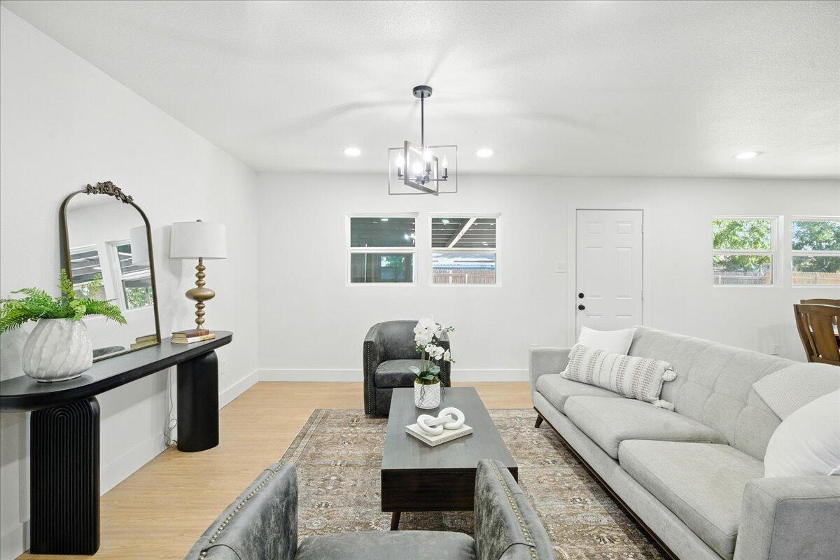 1308 59th Street Lubbock, TX 79412 - Photo 7 of 28 a living room with furniture and a chandelier