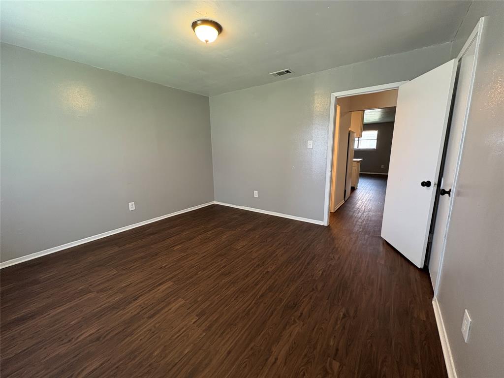 1702 Short Street, Unit C Cleburne, TX 76033 - Photo 3 of 9 wooden floor in an empty room with a mirror