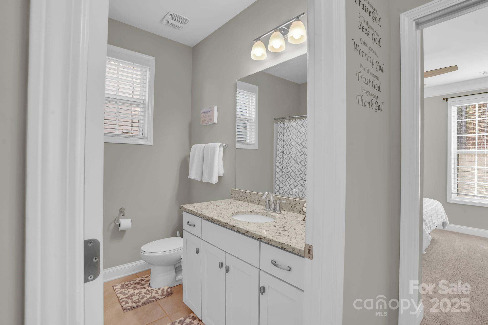 9507 Inverness Bay Road Charlotte, NC 28278 - Photo 13 of 29 a bathroom with a granite countertop toilet a sink and a mirror