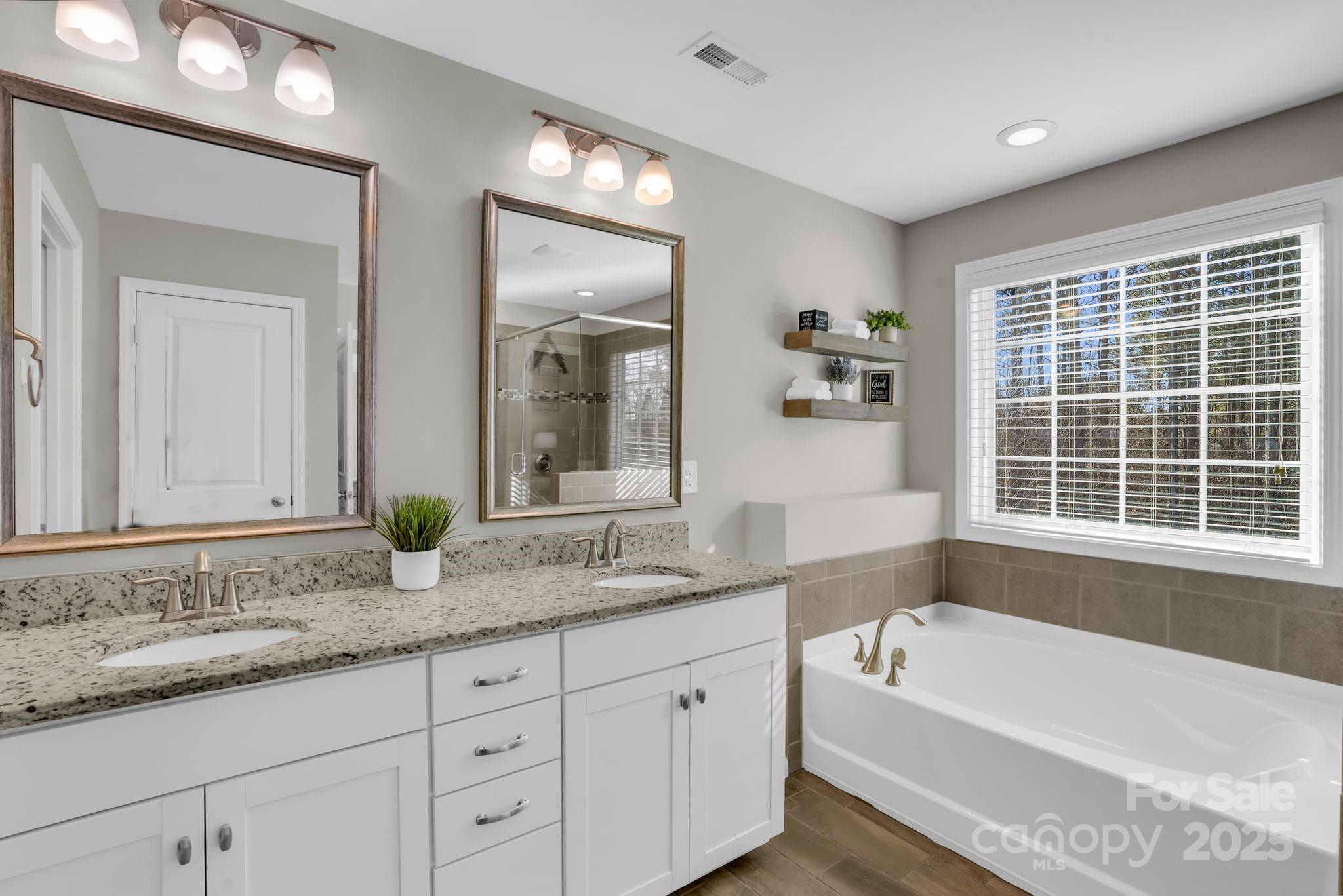 9507 Inverness Bay Road Charlotte, NC 28278 - Photo 16 of 29 a bathroom with a granite countertop tub a sink and a large mirror