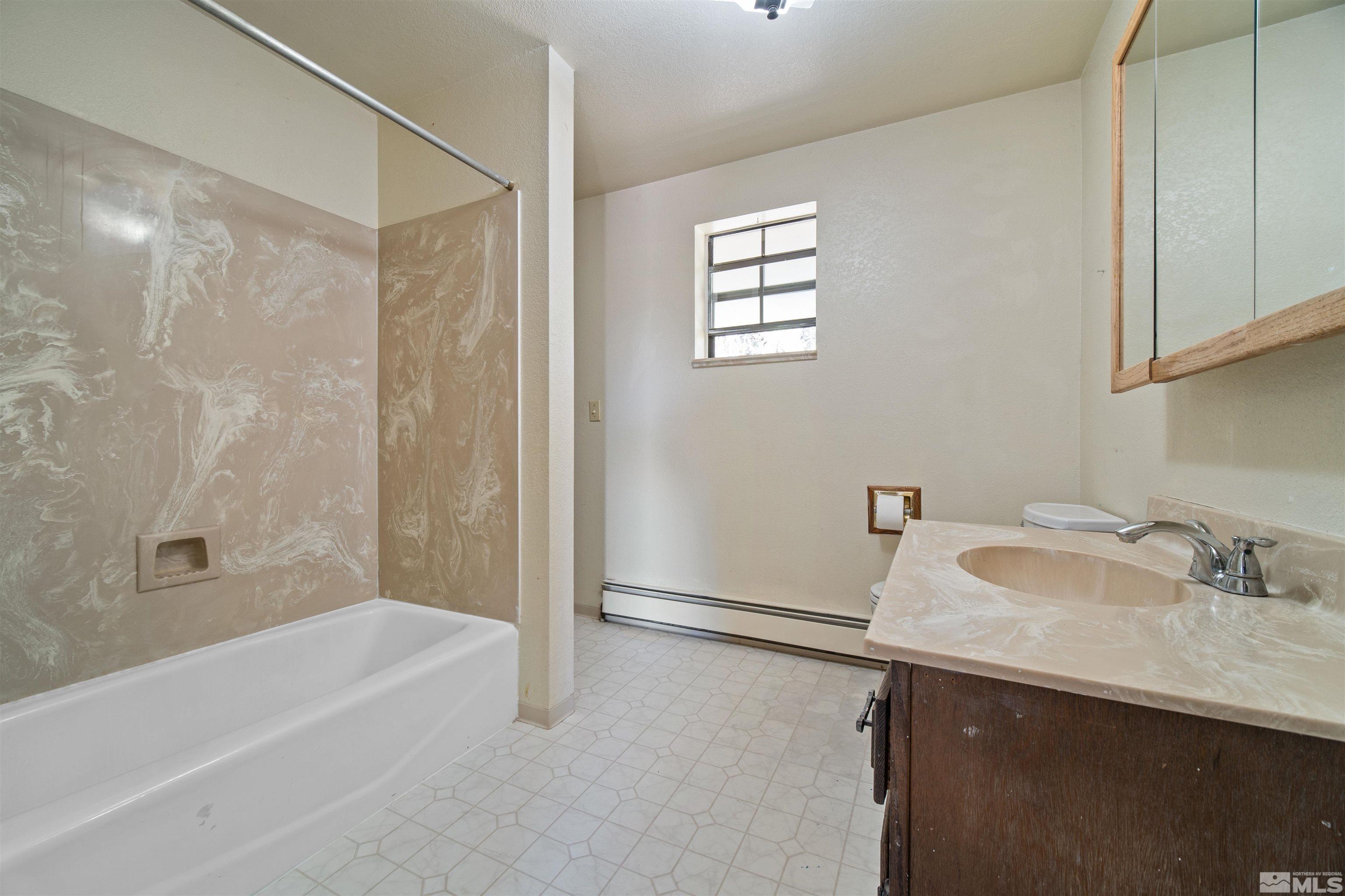 1960 Silverado Road Reno, NV 89521 - Photo 14 of 39 a bathroom with a sink a mirror and a bathtub