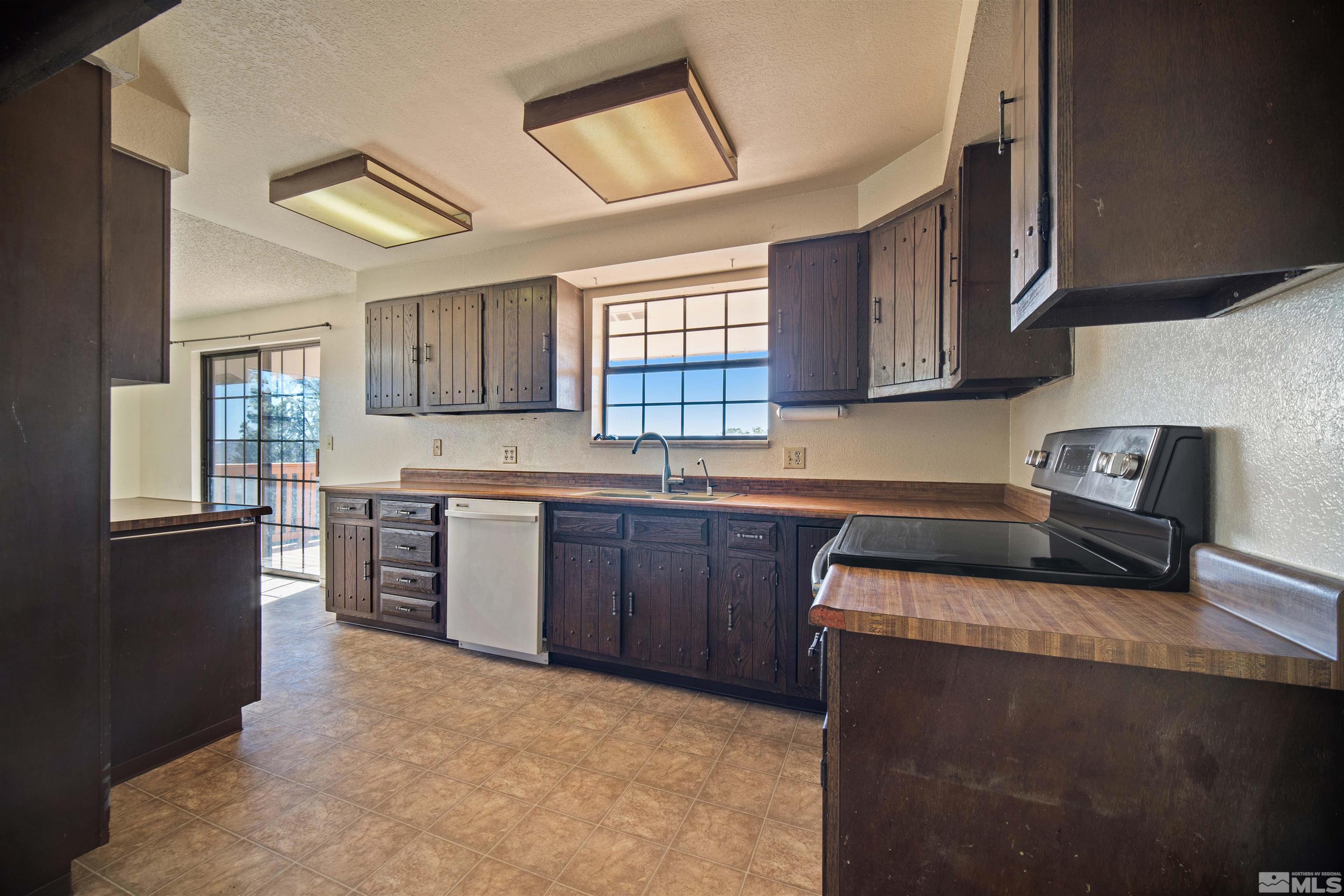 1960 Silverado Road Reno, NV 89521 - Photo 4 of 39 a kitchen with stainless steel appliances granite countertop a stove sink and cabinets