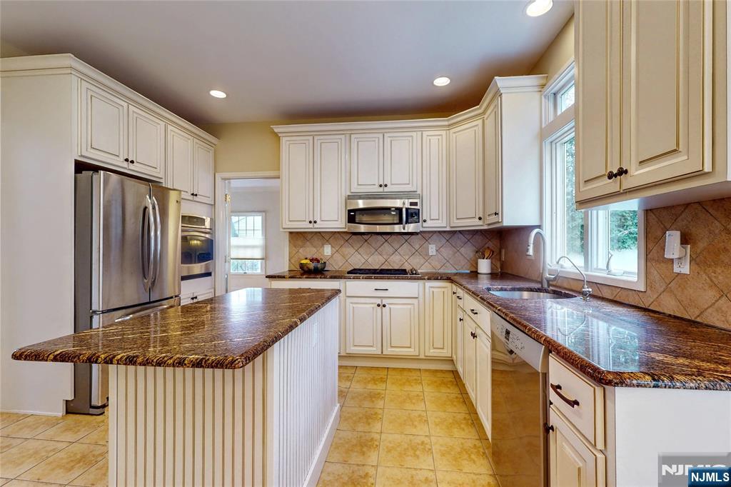 10 Hope Street Montvale, NJ 07645 - Photo 5 of 44 a kitchen with kitchen island granite countertop a sink appliances cabinets and counter space