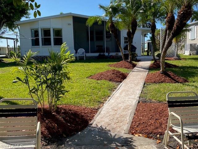 222 Riverwood Road Naples, FL 34114 - Photo 18 of 23 a front view of a house with garden