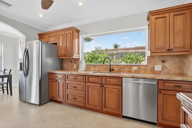 a kitchen with stainless steel appliances granite countertop a refrigerator and a sink