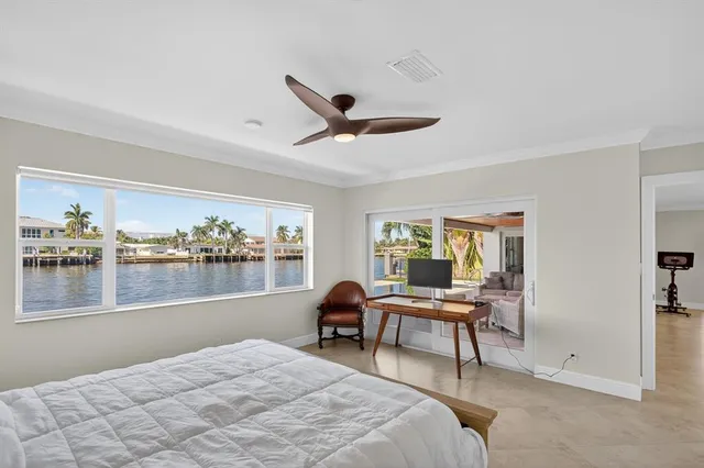 a bedroom with furniture and a large window