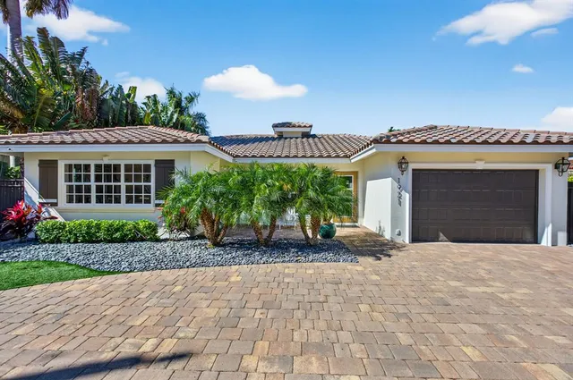 a view of a house with a yard and potted plants