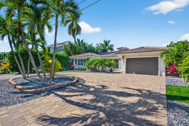 a front view of a house with a yard and potted plants