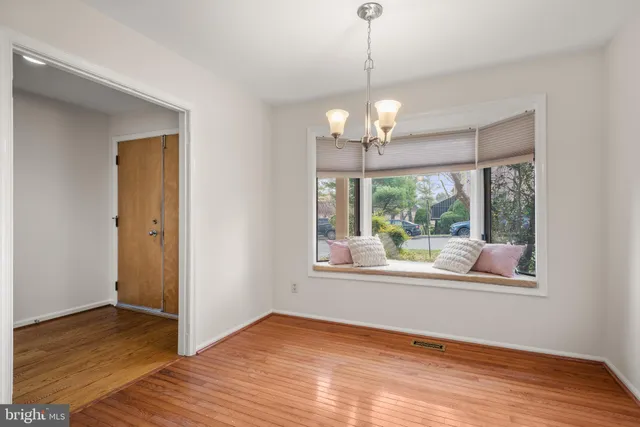 a view of a room with wooden floor chandelier and a window