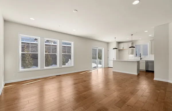 a view of an empty room with a kitchen stove and a window