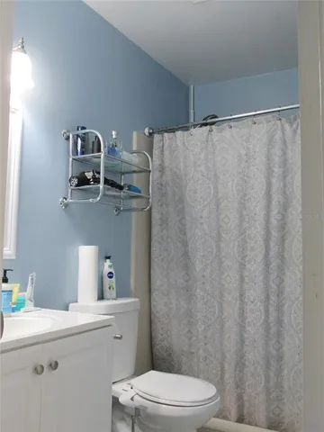 a bathroom with a sink a toilet and shower curtain