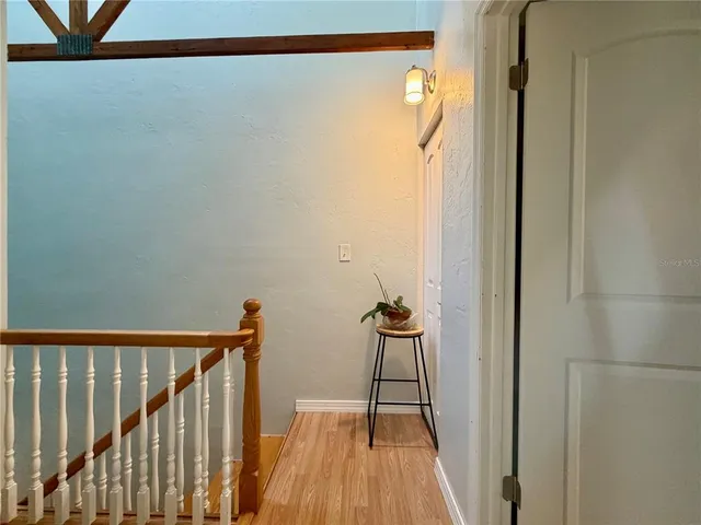 a view of a hallway with wooden floor and staircase