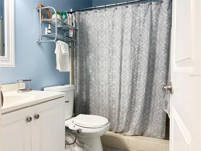 a bathroom with a sink a toilet and shower curtain