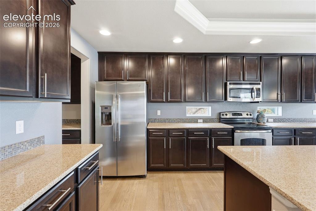 2264 Reed Grass Way Colorado Springs, CO 80915 - Photo 7 of 50 a kitchen with kitchen island granite countertop stainless steel appliances and sink