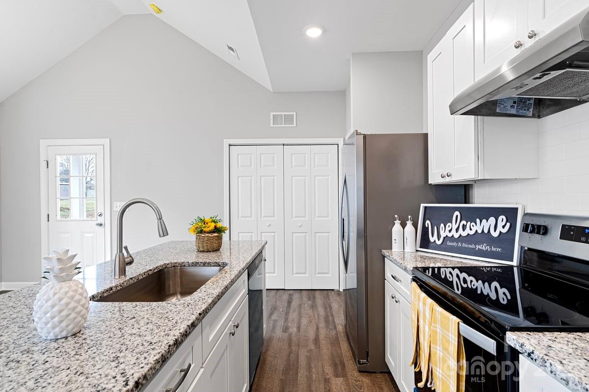 422 Queens Road Gastonia, NC 28052 - Photo 2 of 18 a kitchen with granite countertop a stove a sink and a refrigerator