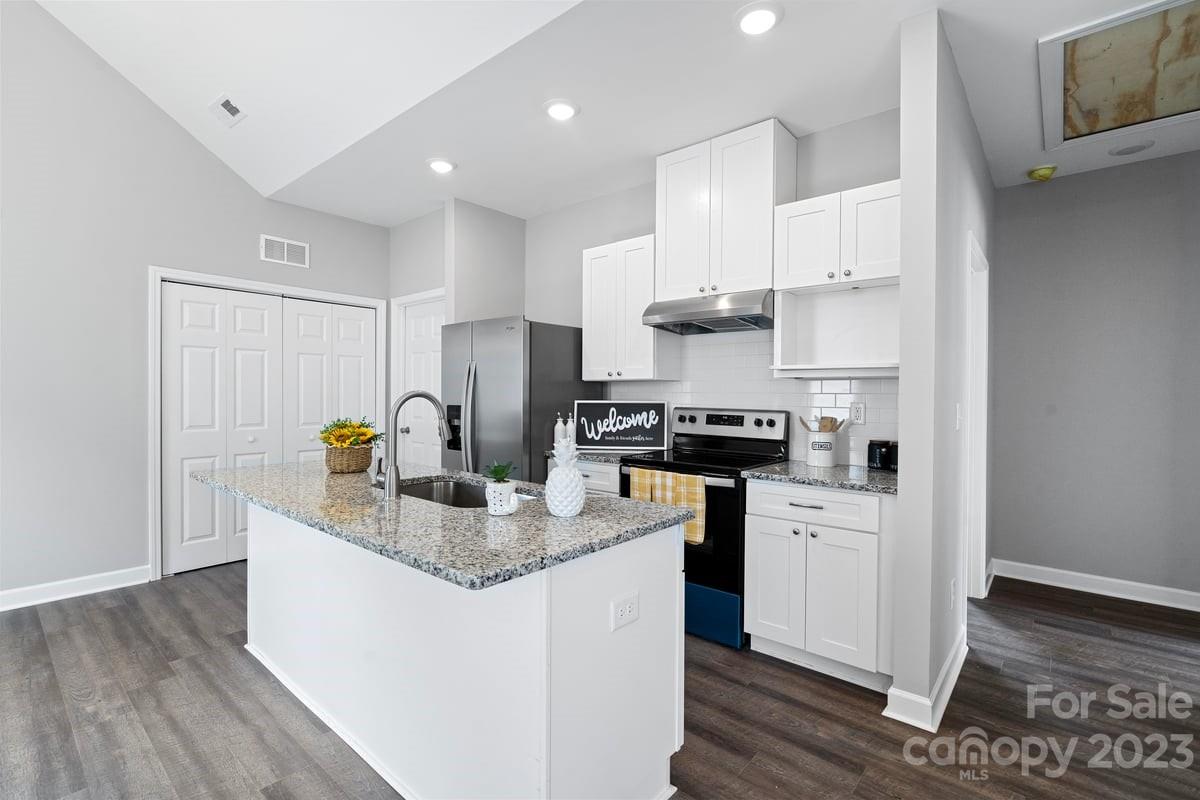422 Queens Road Gastonia, NC 28052 - Photo 3 of 18 a kitchen with kitchen island granite countertop a sink cabinets and wooden floor