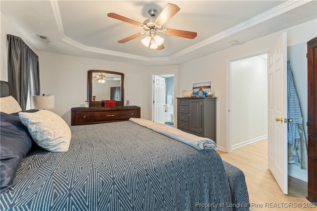 292 Falling Leaf Drive Raeford, NC 28376 - Photo 18 of 40 a bedroom with a large bed and a chandelier
