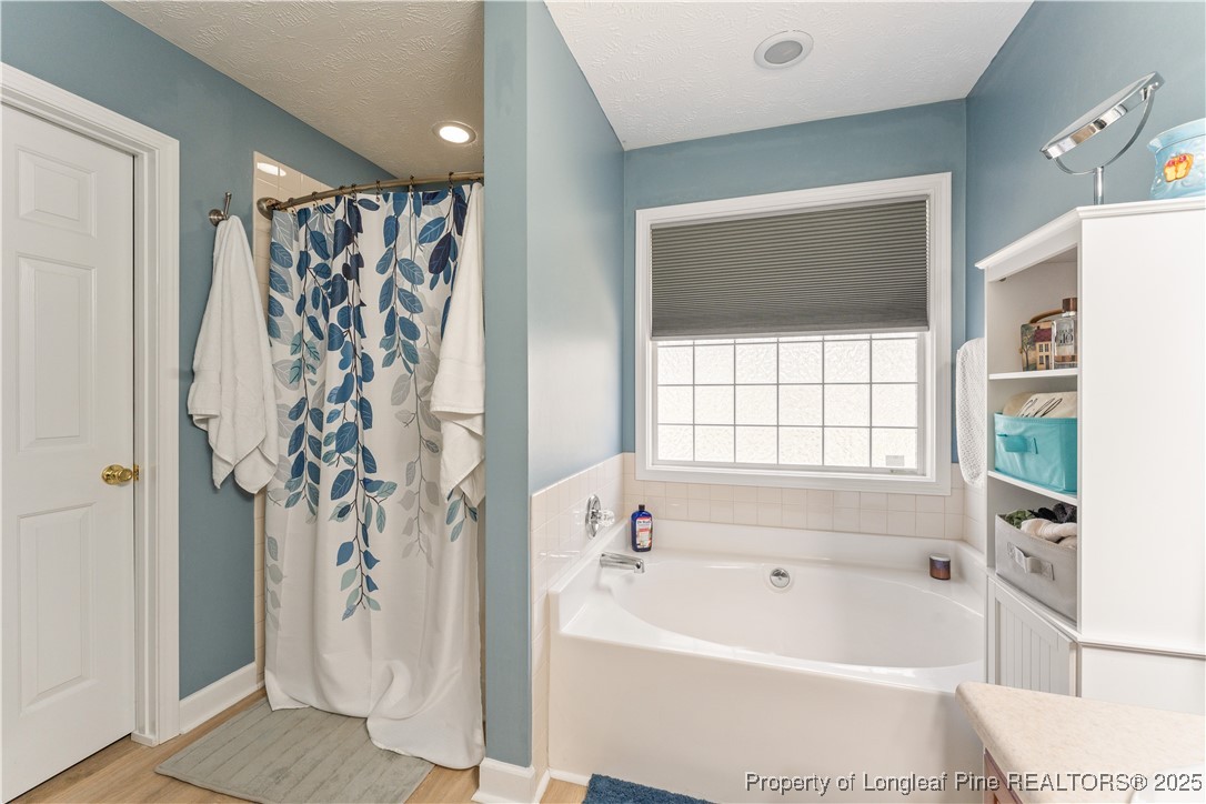 292 Falling Leaf Drive Raeford, NC 28376 - Photo 21 of 40 a bathroom with a bathtub and shower