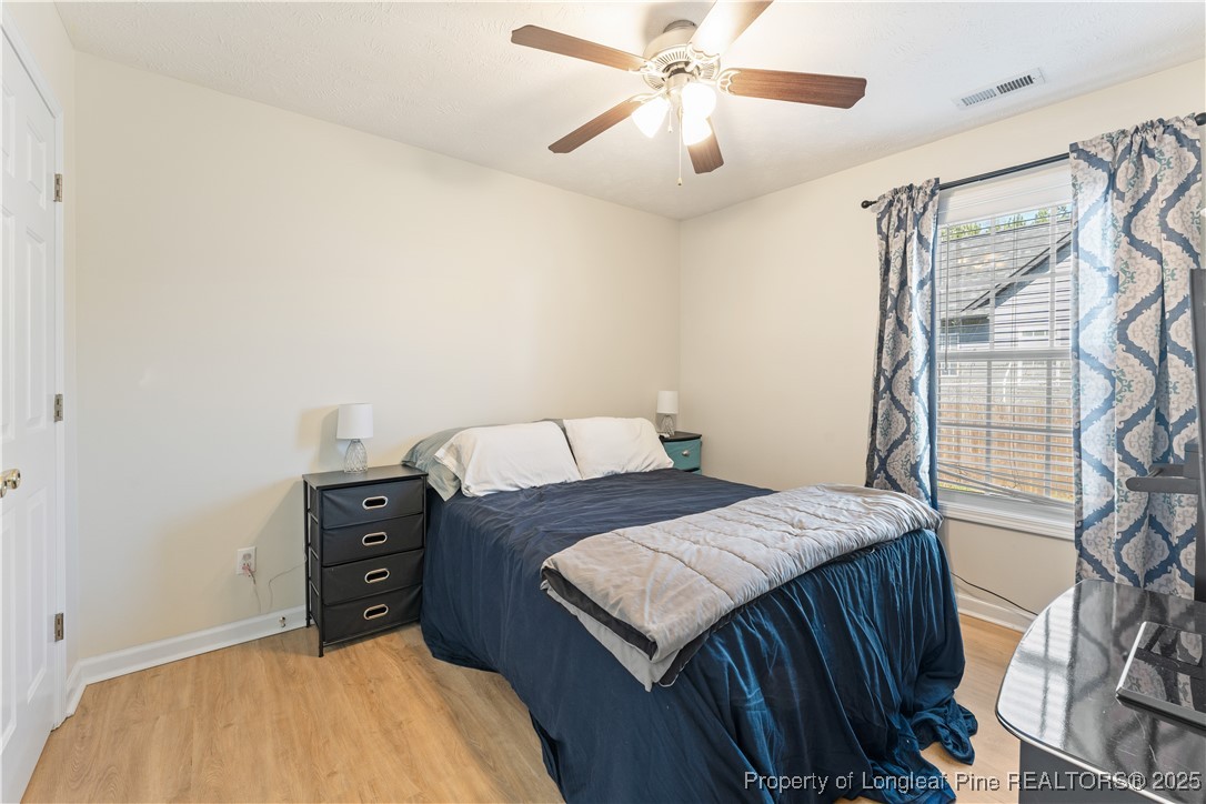 292 Falling Leaf Drive Raeford, NC 28376 - Photo 23 of 40 a bedroom with a bed and a chandelier