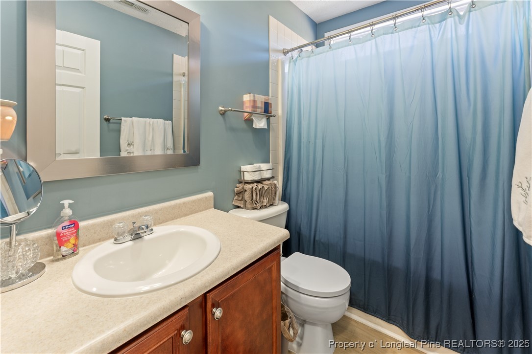 292 Falling Leaf Drive Raeford, NC 28376 - Photo 31 of 40 a bathroom with a sink a toilet and shower curtain
