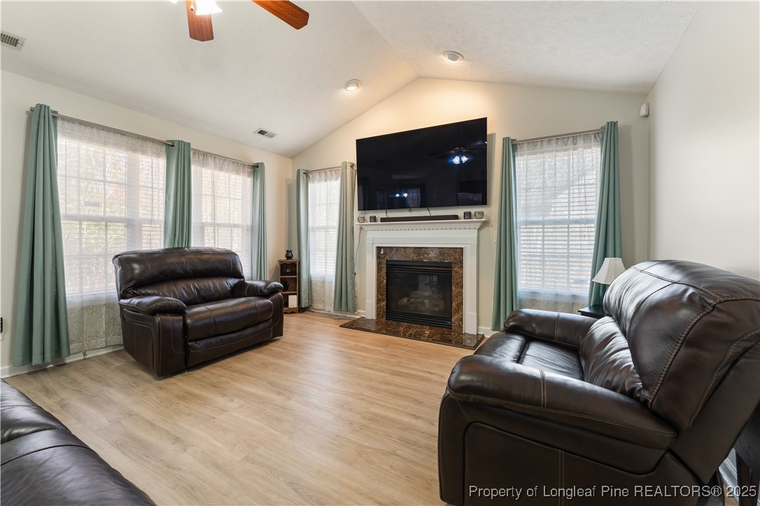 292 Falling Leaf Drive Raeford, NC 28376 - Photo 10 of 40 a living room with furniture a flat screen tv and a fireplace