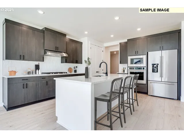 a kitchen with stainless steel appliances a refrigerator sink and microwave