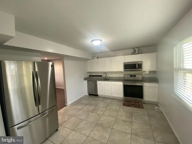 a kitchen with stainless steel appliances granite countertop a refrigerator sink and stove