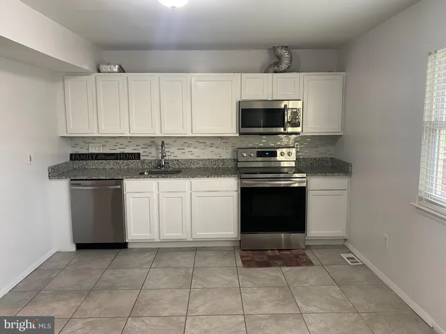 a kitchen with cabinets appliances and a window
