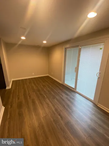 an empty room with wooden floor and entrance