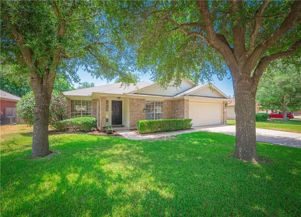 a front view of a house with a yard and trees