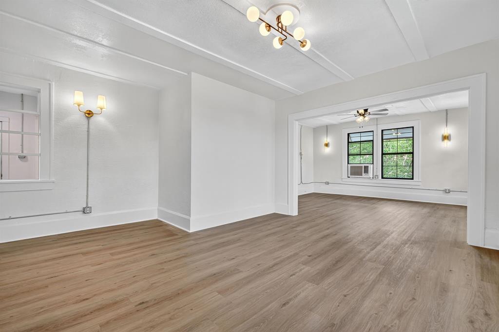 513 Northwest 6th Street, Unit 4 Mineral Wells, TX 76067 - Photo 13 of 34 an empty room with wooden floor chandelier and windows