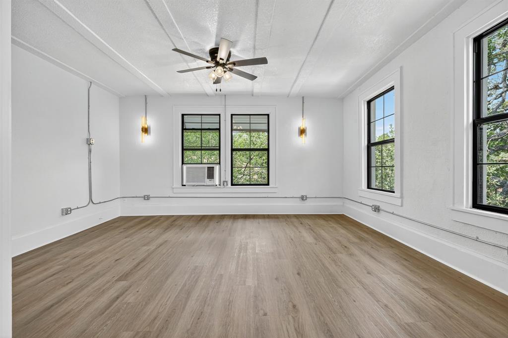 513 Northwest 6th Street, Unit 4 Mineral Wells, TX 76067 - Photo 15 of 34 an empty room with wooden floor chandelier and windows