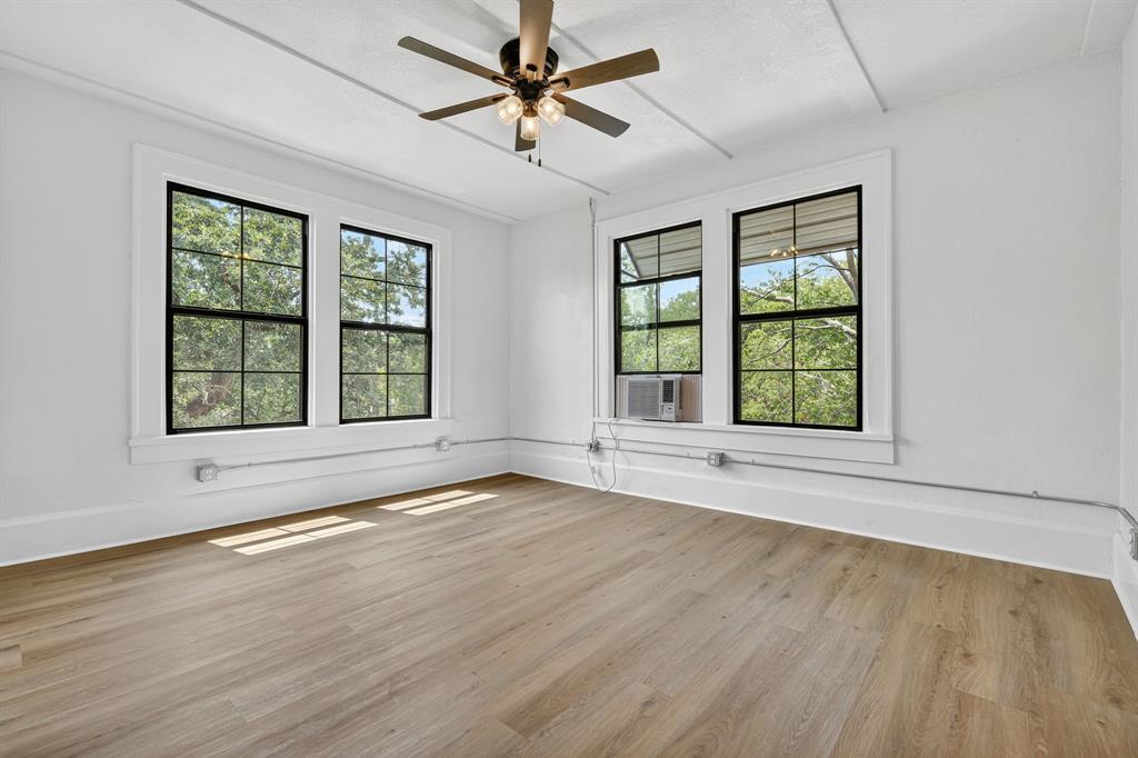 513 Northwest 6th Street, Unit 4 Mineral Wells, TX 76067 - Photo 20 of 34 an empty room with wooden floor and windows
