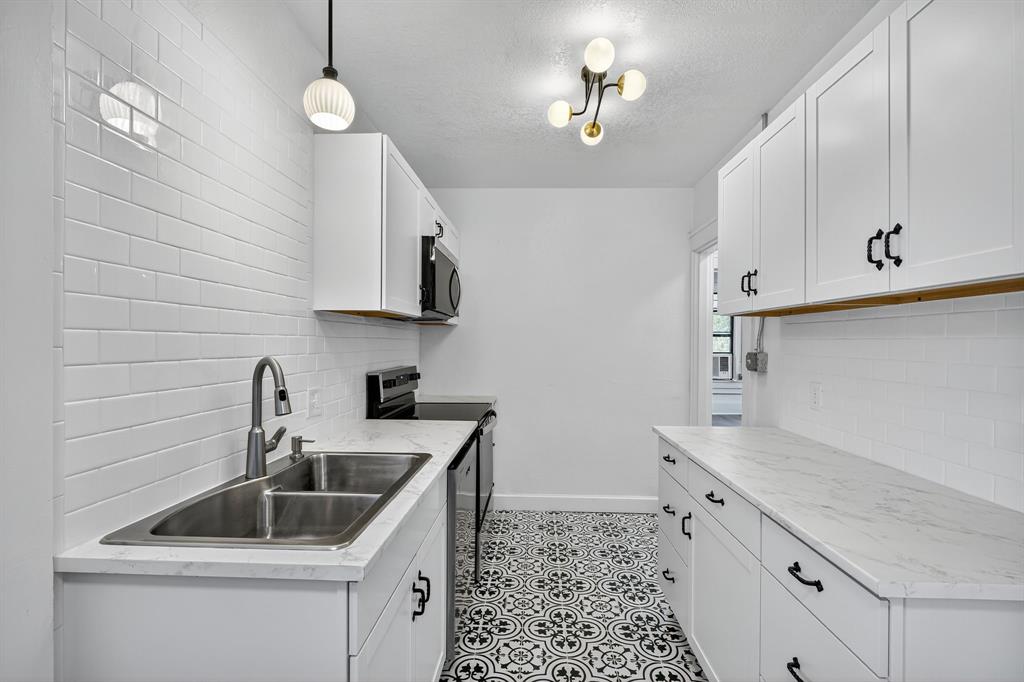 513 Northwest 6th Street, Unit 4 Mineral Wells, TX 76067 - Photo 5 of 34 a kitchen with sink cabinets and window